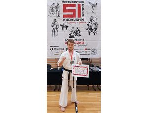 Zawodnicy w strojach karate, na podium.