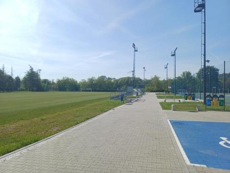 Photo no. 14 (14)
                                                         Zielone boisko piłkarskie, utwardzona ścieżka i jasne błękitne niebo.
                            